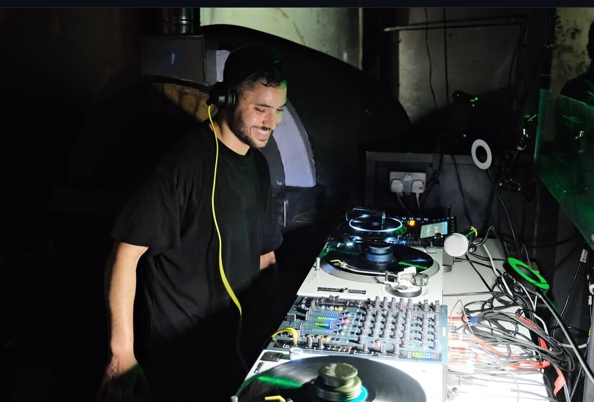 Flávio playing vinyl in a dark room