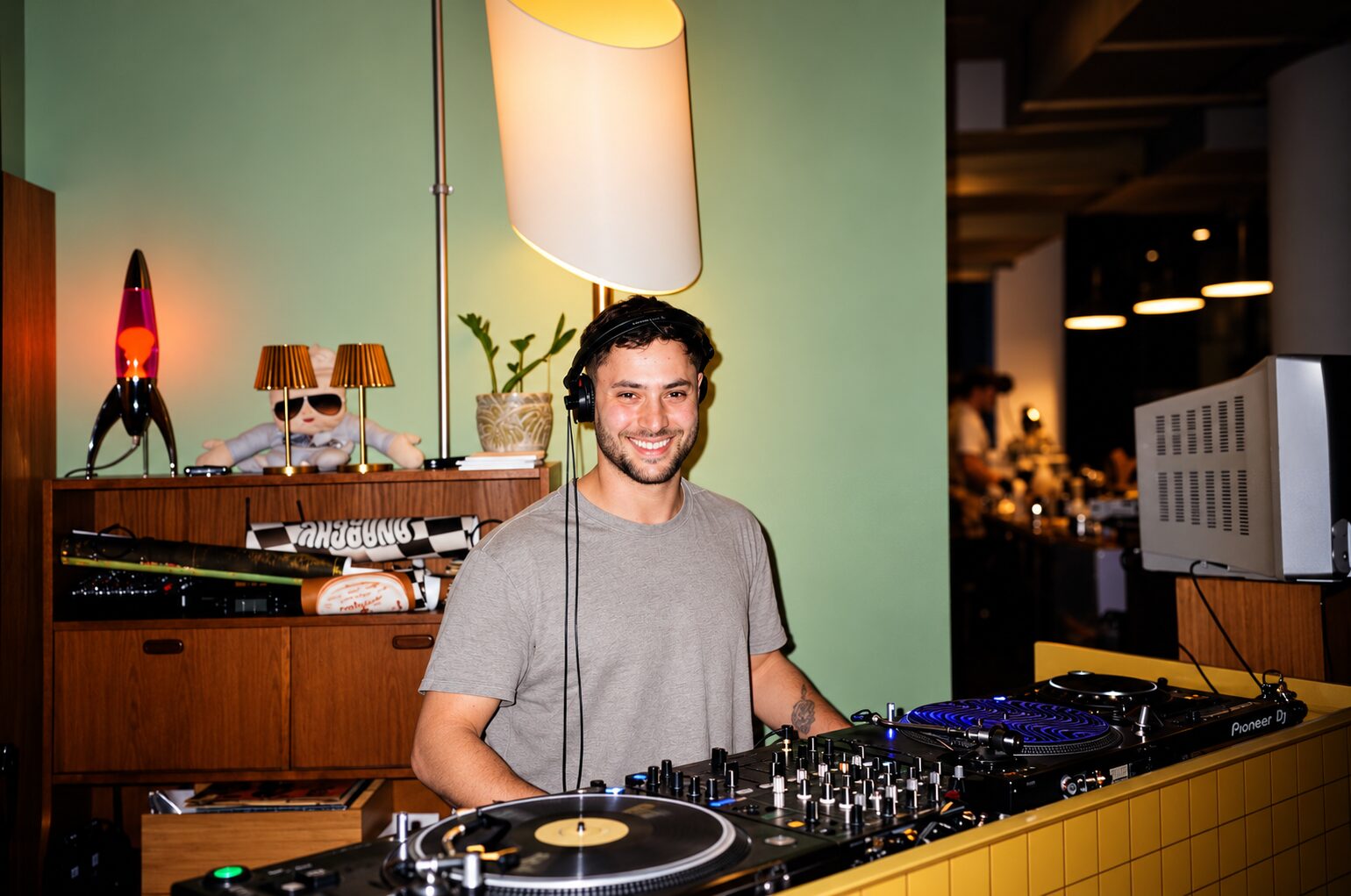 Flávio smiling on the decks, headphones on
